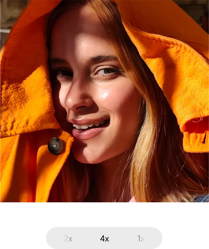 Lány a kamerába mosolyog, kabát a fejére húzva